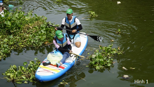 Nhóm anh chị em mặc áo phao và dùng loại thuyền không thể chìm tự nguyện nhặt rác trên sông làm sạch môi trường sống.