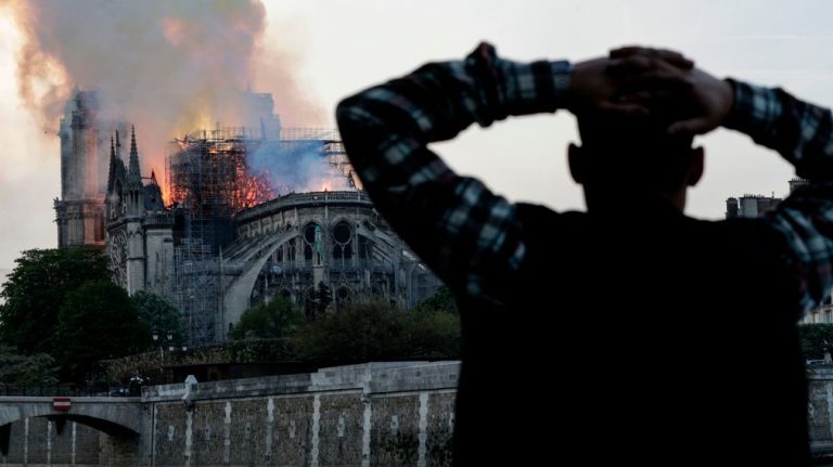 Một người dân Pháp bàng hoàng nhìn ngọn lửa tàn phá Nhà Thờ Đức Bà Paris, một trong những biểu tượng lâu đời của Paris, của nước Pháp hôm 15/4/2019. Ảnh: Geoffroy van der Hasselt/AFP/Getty Images