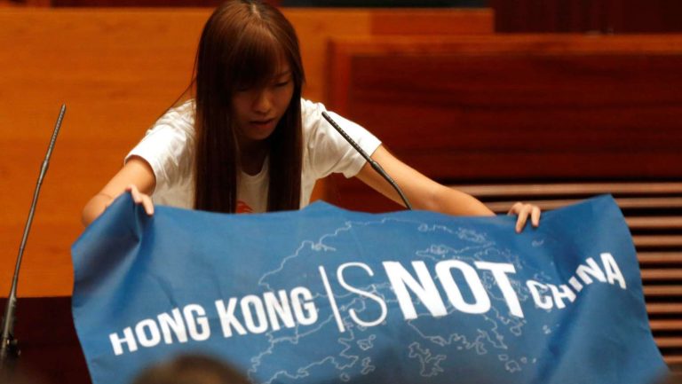 Bức ảnh nổi tiếng của cô Yau Wai Ching (Du Huệ Trinh) giăng biểu ngữ "Hong Kong không phải Trung Quốc" trước khi tuyên thệ nhận trở thành thành viên của Hội Đồng Lập Pháp vào năm 2016. Cô là thành viên của chính đảng Youngspiration, vốn có cảm tình với chủ nghĩa bản thổ Hong Kong. Ảnh: Reuters