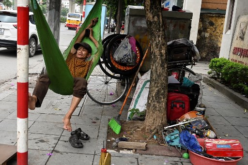 Một người dân với tiệm sửa xe ven đường tại Hà Nội hôm 30 tháng Năm, 2019.  Ảnh: AFP