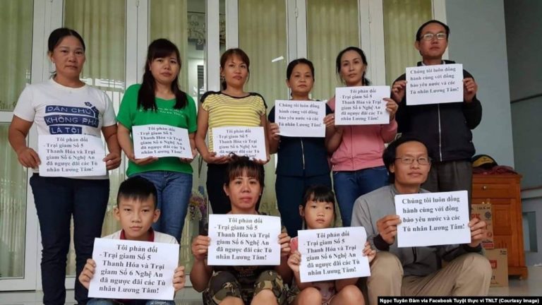 Những người vợ của tù nhân lương tâm cùng ôm bảng phản đối nhà cầm quyền ngược đãi tù nhân. Ảnh: Facebook Tuyệt thực vì TNLT / Ngọc Tuyên Đàm