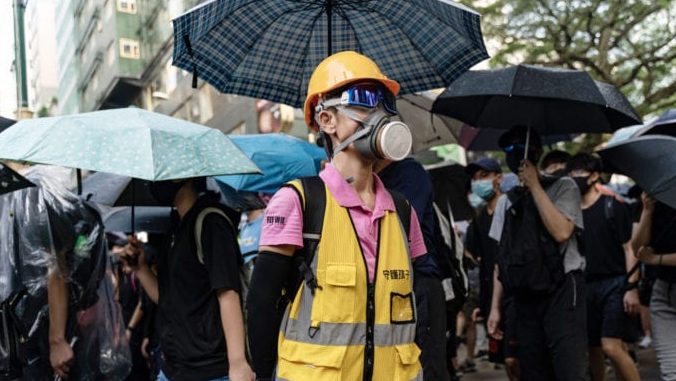 Bất chấp lệnh cấm của chính quyền, người dân Hong Kong vẫn tiếp tục biểu tình, đeo khẩu trang trước trạm cảnh sát Tiêm Sa Chủy (Tsim Sha Tsui) hôm 12 Tháng Mười, 2019. Ảnh: Anthony Kwan/ Getty Images