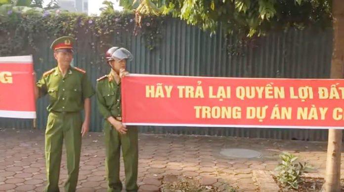 Nhiều người mang sắc phục công an căng băng rôn biểu tình đòi quyền lợi ở huyện Đông Anh, Hà Nội. Ảnh chụp từ một video clip loan tải trên mạng xã hội Facebook.