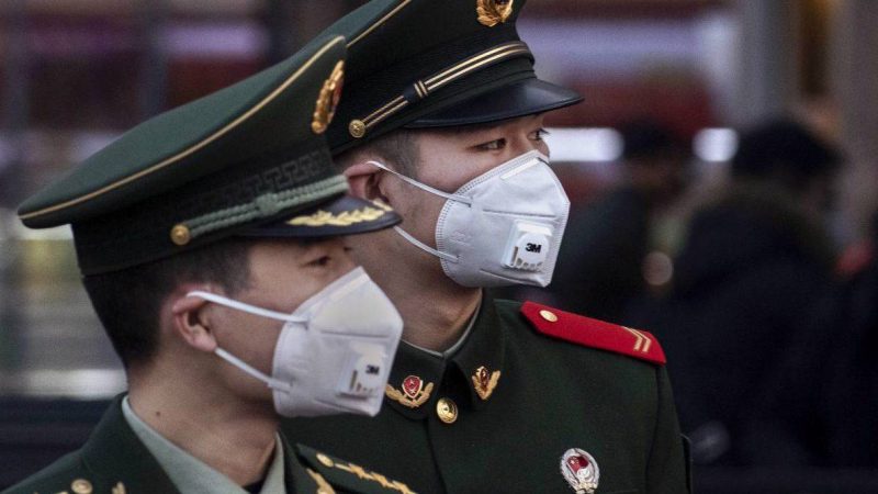 Hai viên công an Trung Quốc mang khẩu trang y tế tại ga Bắc Kinh trước lễ hội mùa xuân hằng năm tại Bắc Kinh 22/1/2020. Ảnh: Kevin Frayer/Getty Images