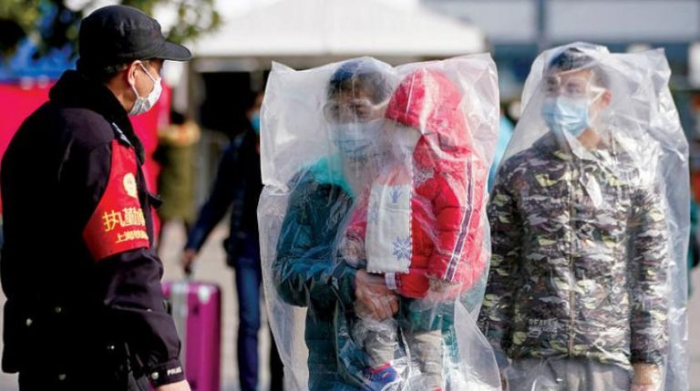 Hành khách Trung Quốc mang khẩu trang, trùm túi nhựa tại ga xe lửa Thượng Hải trong khi nước nầy cố gắng cân bằng giữa ngăn chặn dịch viêm phổi Vũ Hán lây lan và trở lại làm việc. Ảnh: Reuters