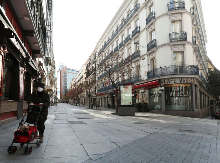 Một phụ nữ mang khẩu trang đi trên một phố chính vắng ngắt ở thủ đô Madrid. Tây Ban Nha đã công bố tình trạng khẩn cấp để ngăn chặn dịch COVID-19 lây lan. Ảnh: Sergio Pérez /Reuters