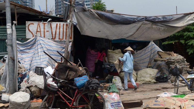 Vựa thu mua phế liệu, nơi mưu sinh của người nghèo, bên cạnh các tòa nhà hào nhoáng ở Hà Nội. Ảnh: Hoang Dinh Nam/Getty Images