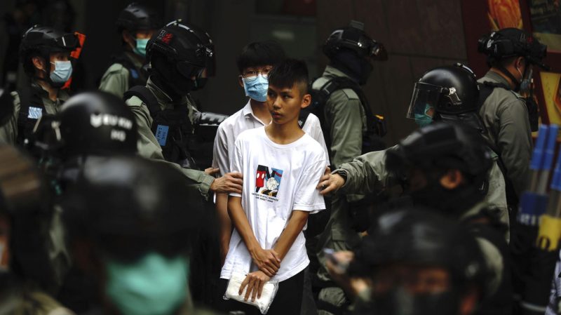 Cảnh sát Hong Kong bắt một thiếu niên tham gia biểu tình chống Trung Quốc thông qua luật kiểm soát cựu thuộc địa này của Anh. Đây là một trong những lý do làm cho Mỹ và Trung Quốc đối đầu. Ảnh: AP/ Kin Cheung