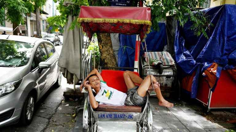 Ở Việt Nam, khi chính quyền nói tới “dân” nhiều khi phải hiểu đó là nói tới cán bộ đảng viên chứ không phải “quần chúng.” Một xã hội như vậy không thể coi là “có dân chủ.” Trong hình, một người đạp xích lô Việt Nam chợp mắt trong bóng râm dọc một con đường ở Hà Nội hôm 17 Tháng Sáu, 2020. Ảnh: Manan Vatsyayana/AFP via Getty Images