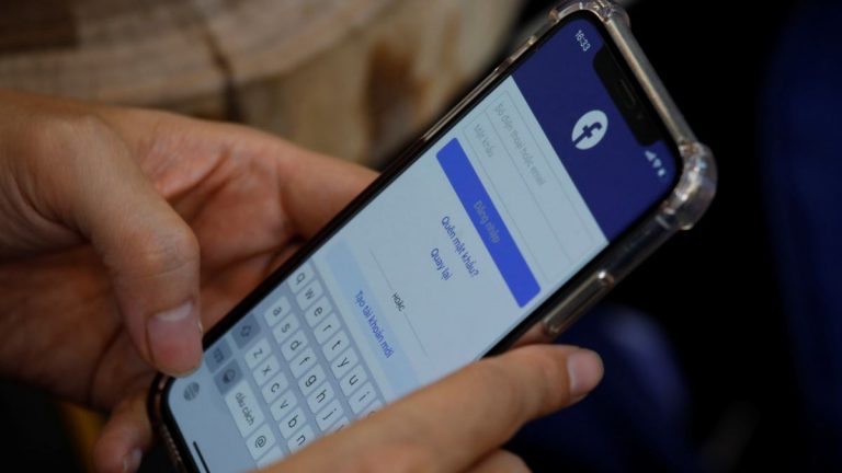 Một người dùng truy nhập mạng xã hội Facebook trên chiếc điện thoại trong một quán cà phê ở Hà Nội. Ảnh: Yahoo Finance/ Reuters
