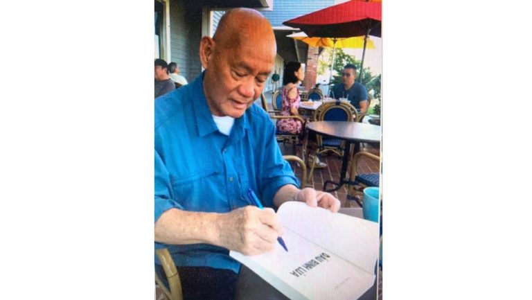 Nhà văn, cựu sĩ quan QLVNCH ký tặng hồi ký "Dấu Linh Lửa", một tác phẩm nổi tiếng của ông. Ảnh: Bauxite Việt Nam
