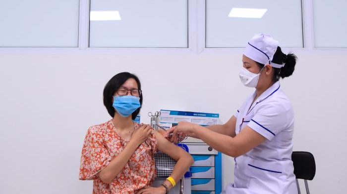 Một người phụ nữ được tiêm vắc-xin AstraZeneca ngừa COVID-19 tại Hà Nội hôm 27/6/2021. Ảnh: AP