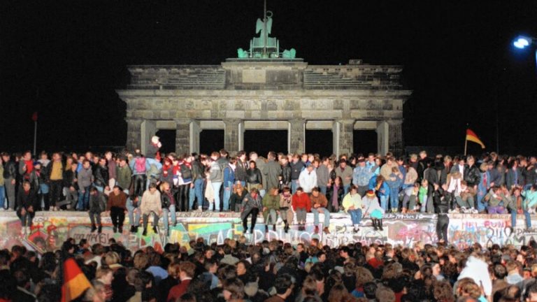 Dân chúng Đông và Tây Bá Linh vui mừng đứng trên bức tường Berlin ngay trước Cổng Brandenburg, thủ đô Berlin vào tối ngày 11/9/1989. Ảnh: EPA/ STR