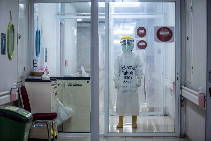 Một nhân viên y tế mặc bộ áo phòng chống dịch có dòng chữ “Chúc mừng năm mới 2021” để khích lệ tinh thần các bệnh nhân COVID-19 tại Bệnh viện thành phố Bogor ở Tây Java, Indonesia, vào ngày 1 tháng Giêng, 2021. Ảnh: ADITYA AJI/AFP VIA GETTY IMAGES