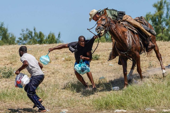 Một nhân viên tuần tra biên giới Hoa Kỳ ngồi trên lưng ngựa cố gắng ngăn một người tỵ nạn Haiti đang tìm cách tiến vào một đồn điền bên bờ sông Rio Grande ở Del Rio, Texas, vào ngày 19/9/2021. Ảnh: PAUL RATJE/AFP VIA GETTY IMAGES