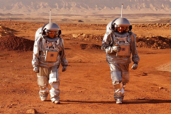 Hai phi hành gia đến từ Châu Âu và Israel được huấn luyện để lên Sao Hỏa, đang đi bộ trong bộ trang phục vũ trụ tại miệng núi lửa Ramon ở sa mạc Negev phía Nam Israel vào ngày 10/10/2021. Có sáu phi hành gia đến từ Bồ Đào Nha, Tây Ban Nha, Đức, Hà Lan, Áo và Israel đã bị tách ra khỏi cuộc sống của thế giới loài người trong suốt tháng Mười và họ chỉ có thể sống trên Sao Hỏa với những bộ trang phục vũ trụ như thế này. Ảnh: JACK GUEZ/AFP VIA GETTY IMAGES