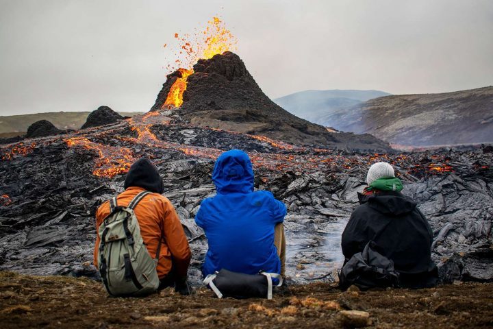 Các hikers đang ngồi nhìn dung nham chảy ra từ miệng núi lửa Fagradalsfjall cách thủ đô Reykjavik, Iceland, khoảng 25 dặm (40km) về phía Tây vào ngày 21/3/2021. Ảnh: JEREMIE RICHARD/ AFP VIA GETTY IMAGES
