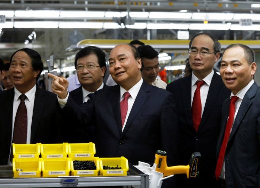 Thủ Tướng Nguyễn Xuân Phúc và các quan chức chính phủ khác đến thăm nhà máy sản xuất xe hơi ở Hải Phòng của tập đoàn Vingroup hôm 14/6/2019. Ông Phạm Nhật Vượng - chủ tập đoàn - đứng ngoài cùng bên phải. Ảnh: Reuters