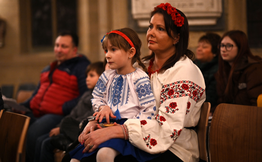 Một bé gái mặc quốc phục Ukraine tham dự buổi cầu nguyện cho hòa bình ở Ukraine tại Nhà thờ Bradford ở miền bắc nước Anh vào ngày 24/2/2023. Ảnh: Oli Scarff/ AFP via Getty Images