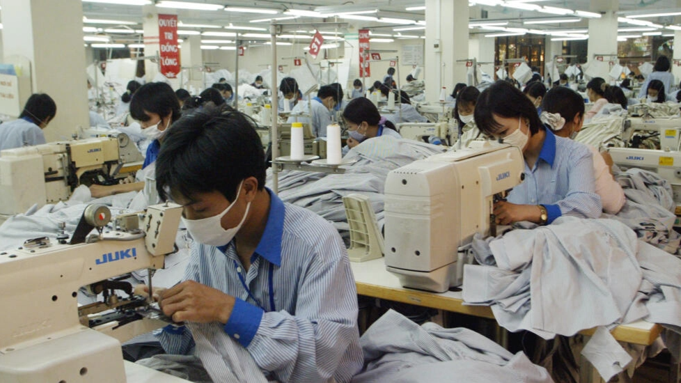 Công nhân tại một nhà máy sản xuất áo thun ở ngoại ô Hà Nội, Việt Nam. Ảnh chụp ngày 09/01/2007. AP - Tran van Minh