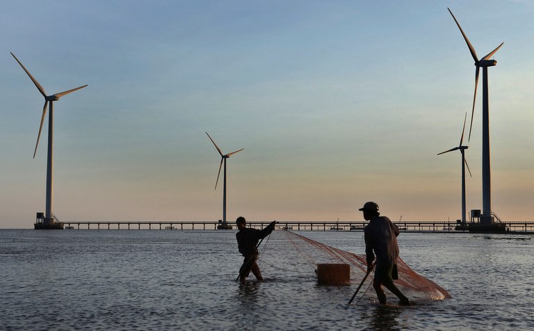 Người dân lưới cá ở khu vực phía trước của các turbine gió ở tỉnh Bạc Liêu vào năm 2014. Tập đoàn năng lượng tái tạo khổng lồ Ørsted của Đan Mạch thông báo sẽ rời khỏi thị trường điện gió Việt Nam vào tháng 6/2023 đồng thời giải thích rằng "đạo đức kinh doanh của chúng tôi đã gặp phải những trở ngại." Ảnh: Duy Khoi/AFP