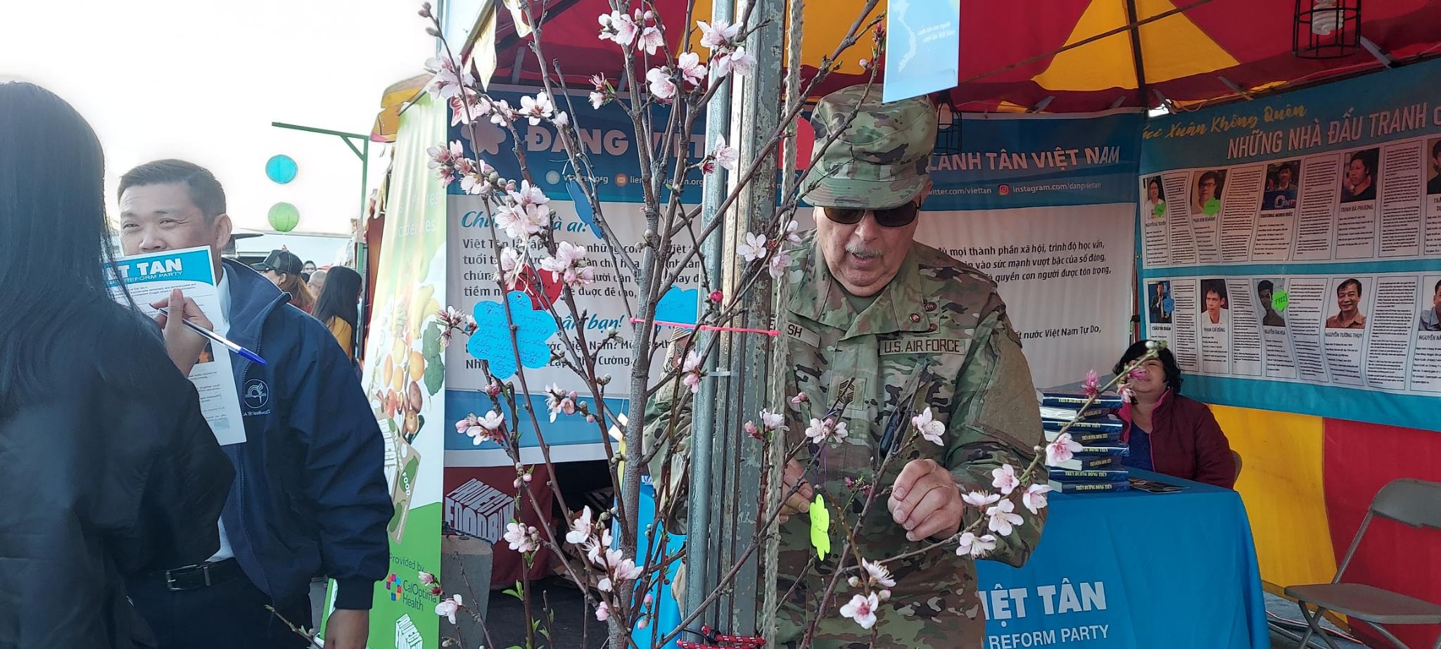 Một quân nhân Mỹ treo mong ước của ông cho Việt Nam lên "Cây Ước vọng" (Wishing Tree) ở quầy thông tin của Việt Tân trong Hội chợ Tết Giáp Thìn 2024 do Tổng hội Sinh viên Việt Nam Nam California tổ chức
