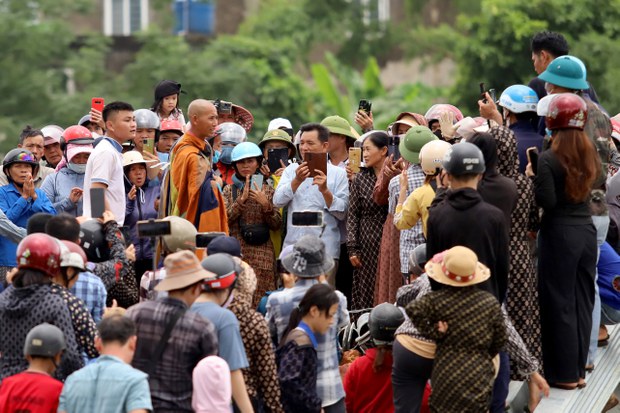 Hình chụp hôm 17/5/2024 khi đoàn nhà sư theo sư Thích Minh Tuệ (giữa) đi qua địa bàn tỉnh Hà Tĩnh. Người dân và các YouTuber, TikToker đi theo quay phim nhà sư và đoàn bộ hành. Ảnh: STR / AFP