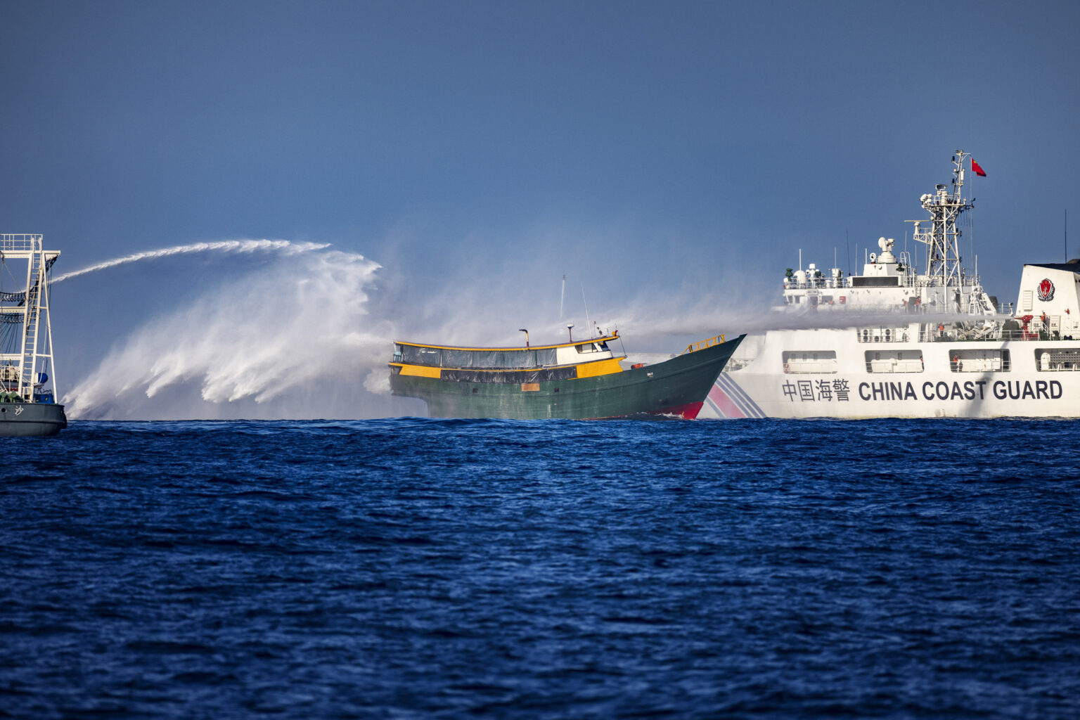 Tàu Cảnh sát biển Trung Quốc (phải) bắn vòi rồng vào một tàu được Hải quân Philippines thuê để thực hiện nhiệm vụ tiếp tế thường lệ cho quân đội đóng tại bãi cạn Scarborough và Bãi Cỏ Mây hôm 5/3/2024 ở Biển Đông. Ảnh: Ezra Acayan/ Getty Images