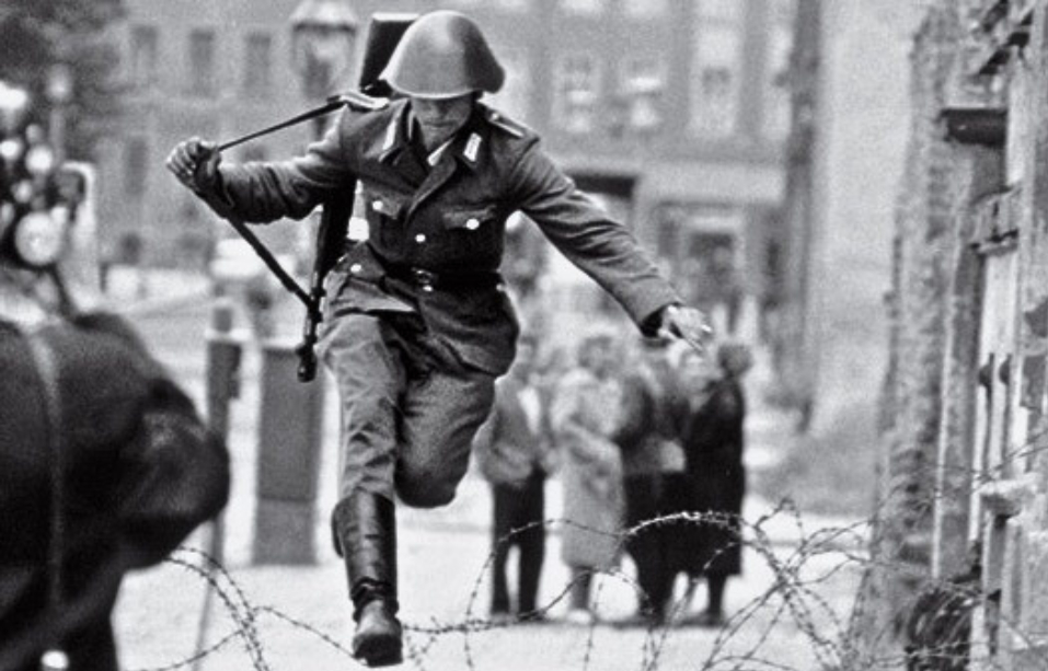 Ảnh tư liệu: Đây là bức ảnh nổi tiếng “Leap into Freedom” - khoảnh khắc lịch sử khi lính biên phòng Đông Đức, Hans Conrad Schumann, nhảy qua hàng rào thép gai để chạy sang Tây Berlin. Ảnh do Peter Leibing chụp trong ngày 15/08/1961, trở thành biểu tượng mạnh mẽ của Chiến tranh Lạnh