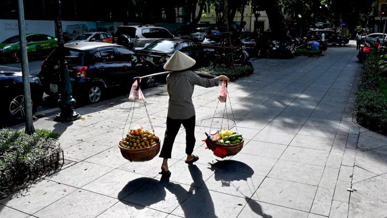 Một người bán hàng rong ở Hà Nội. Ảnh: Nhac Nguyen/ AFP