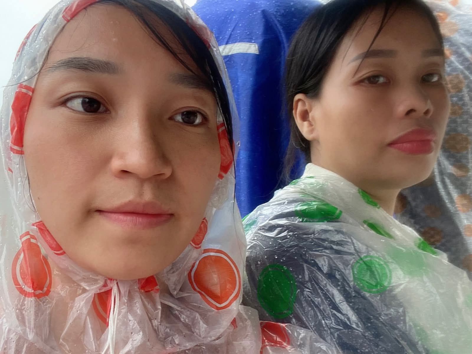 Vợ (Đỗ Thị Thu - trái) và em gái (Trịnh Thị Thảo) của Trịnh Bá Phương đội mưa đứng bên ngoài vòng rào phiên tòa xử anh, ánh mắt kiên nhẫn và bất khuất, trở thành một biểu tượng câm lặng của tình thân và lòng can đảm. Ảnh: Tuần Việt Nam