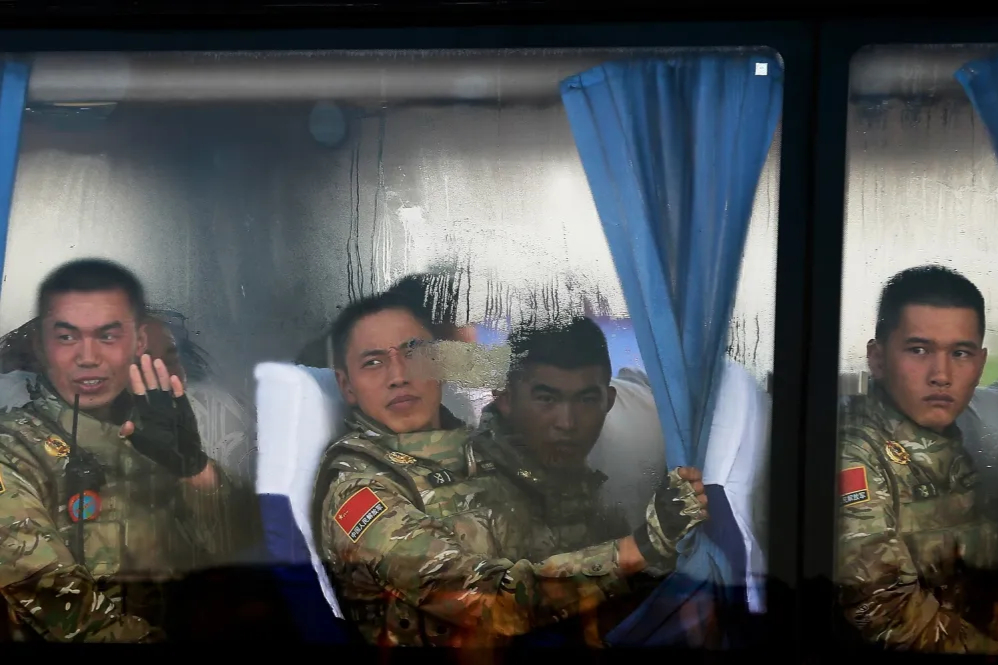 Các binh lính thuộc Quân Giải phóng Nhân dân Trung Quốc nhìn ra ngoài từ cửa sổ xe buýt khi họ đến Quảng trường Thiên An Môn để tham gia cuộc duyệt binh ở Bắc Kinh ngày 3/9/2015. Ảnh: Andy Wong - Pool/ Getty Images