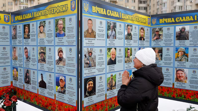 Một phụ nữ cầu nguyện trước di ảnh người thân tại khu tưởng niệm các chiến sĩ Ukraine đã hy sinh vì tổ quốc, nhân kỷ niệm 4 năm chiến đấu chống quân Nga xâm lược, ngày 24/02/2026. Ảnh: Reuters - Valentyn Ogirenko