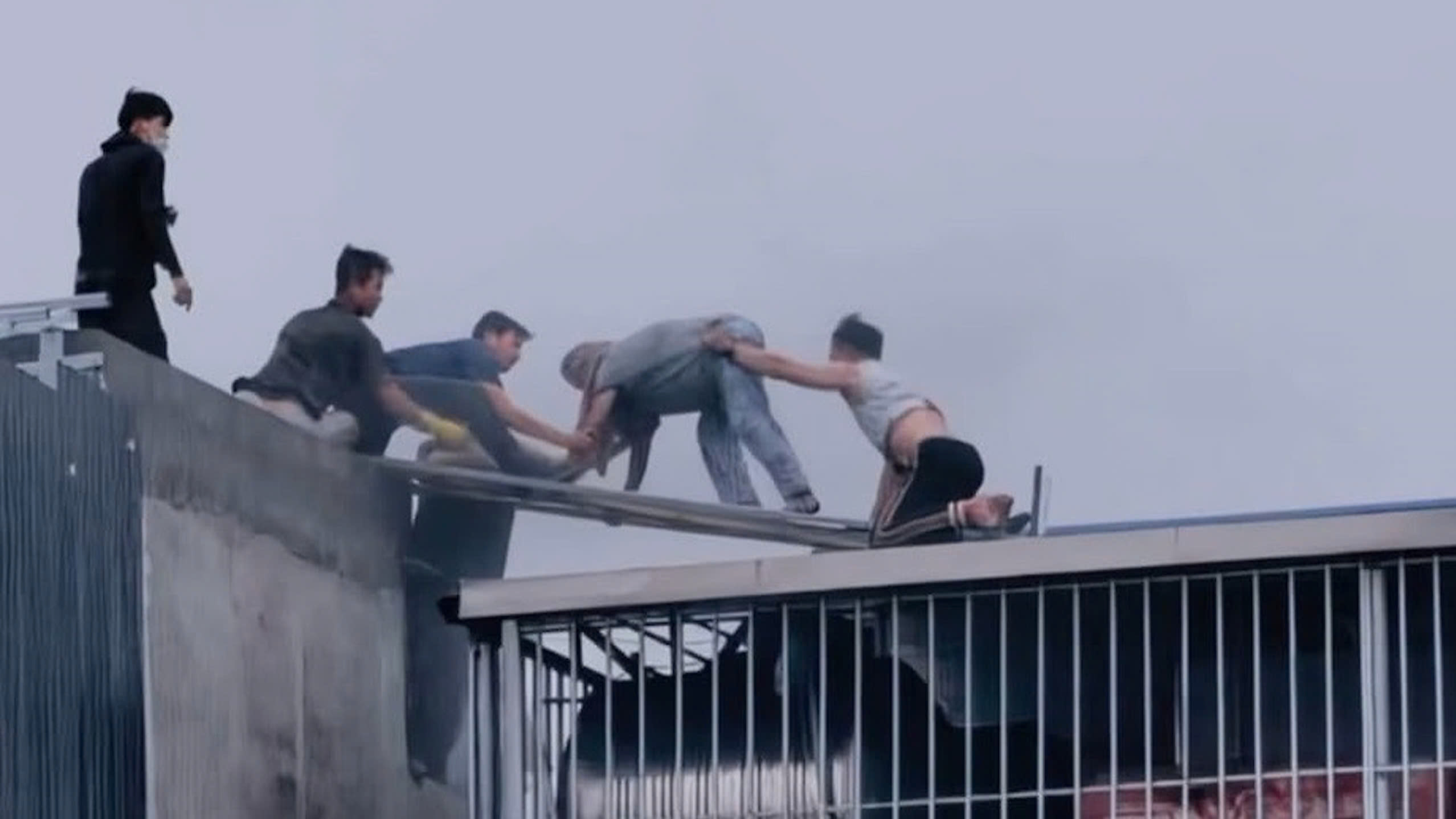 Nhiều người hàng xóm liều mình cứu thoát 7 người kẹt trên sân thượng trong vụ hỏa hoạn tại hẻm 218 Lĩnh Nam (phường Hoàng Mai, Hà Nội) hôm 24/3/2026. Ảnh: Báo Người Lao Động