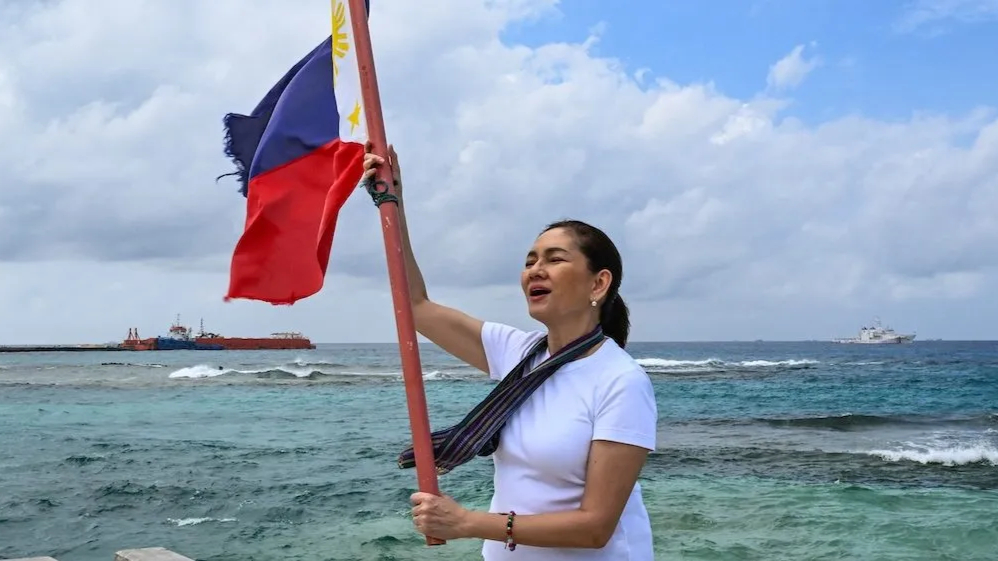 Thượng nghị sĩ Philippines Risa Hontiveros giương cao cờ Philippines trên đảo Thị Tứ ở Biển Đông vào ngày 21 tháng 2 năm 2026. Ảnh: Jam Sta Rosa/ AFP