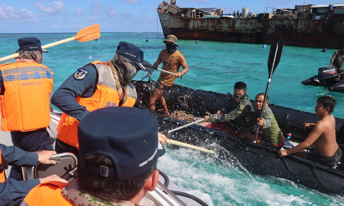 Binh lính Hải quân Philippines đụng độ Lực lượng Cảnh sát biển Trung Quốc (áo phao màu cam) hôm 20/7/2026 gần chiếc tàu chiến Philippines mắc cạn tại Bãi Cỏ Mây (Second Thomas Shoal) trên Biển Đông. Ảnh: Reuters
