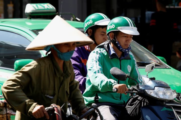 Một tài xế lái xe GrabBike chở khách trên đường phố Hà Nội hôm 29/12/2018. Ảnh: Reuters