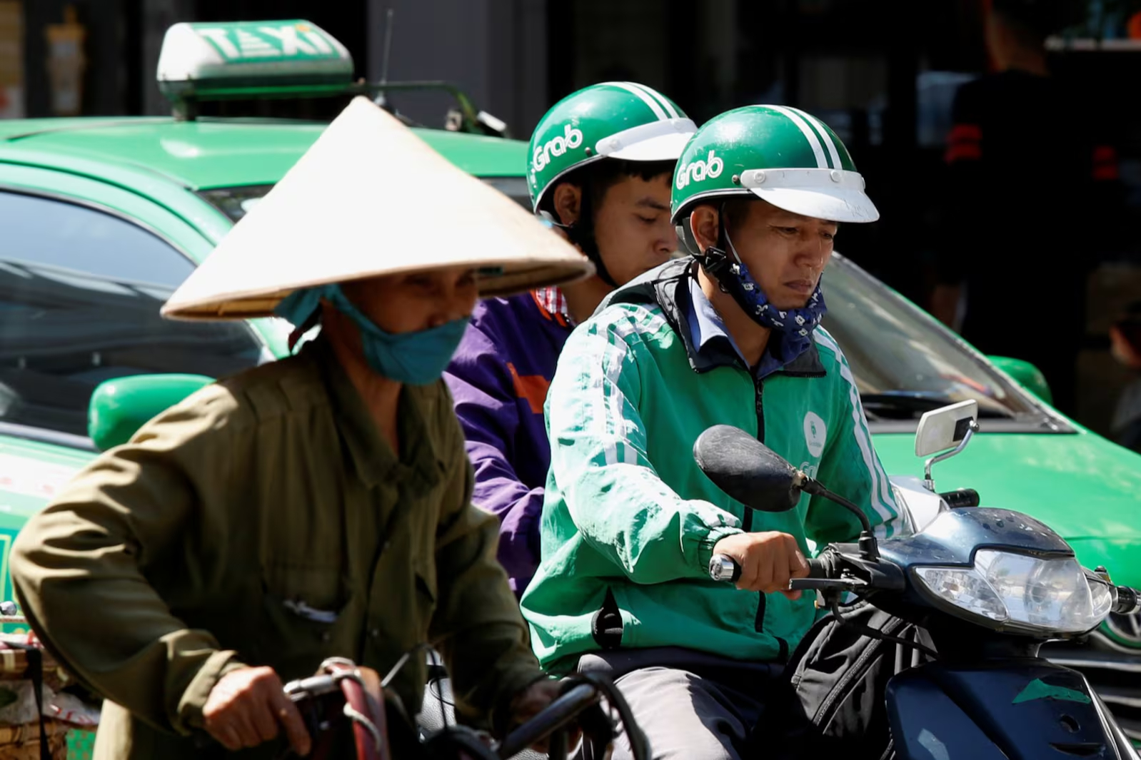 Một tài xế lái xe GrabBike chở khách trên đường phố Hà Nội hôm 29/12/2018. Ảnh: Reuters